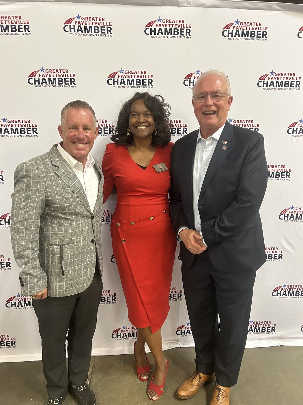 Bryan Moore with two other guests in front of a Greater Fayetteville Chamber backdrop.