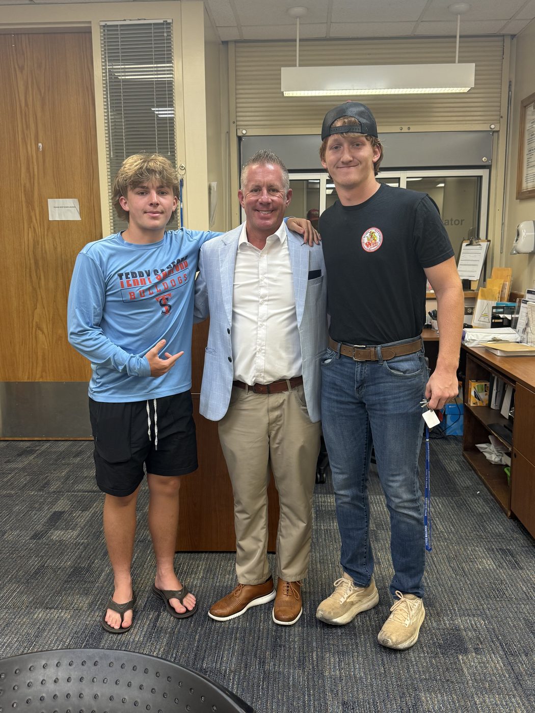 Bryan Moore with his two sons in a school front office.